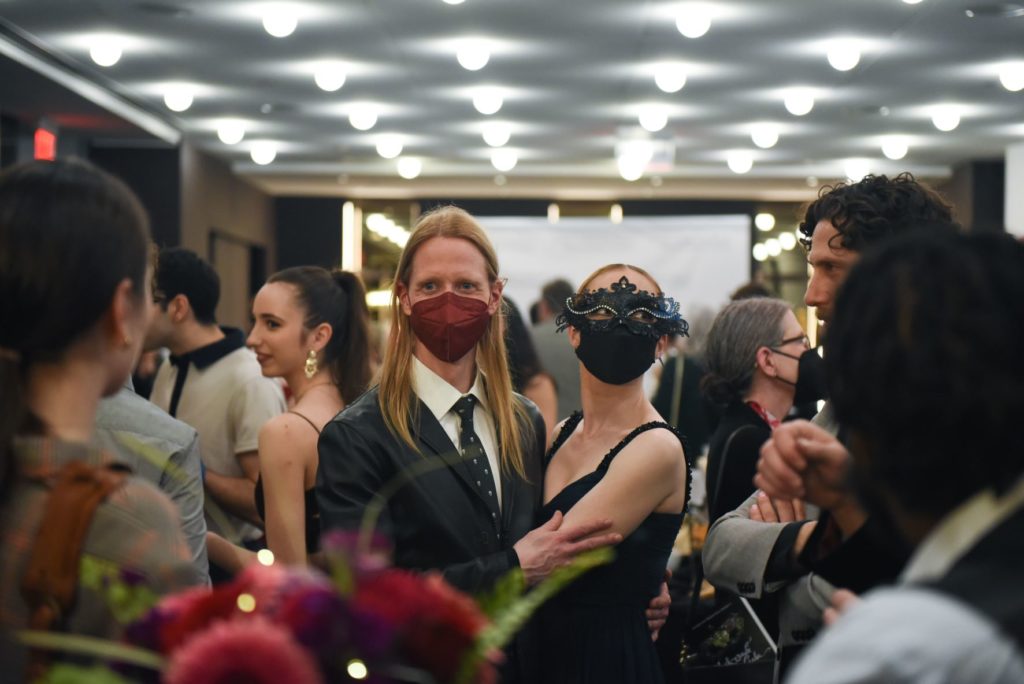 People in formal wear from a masquerade event. 